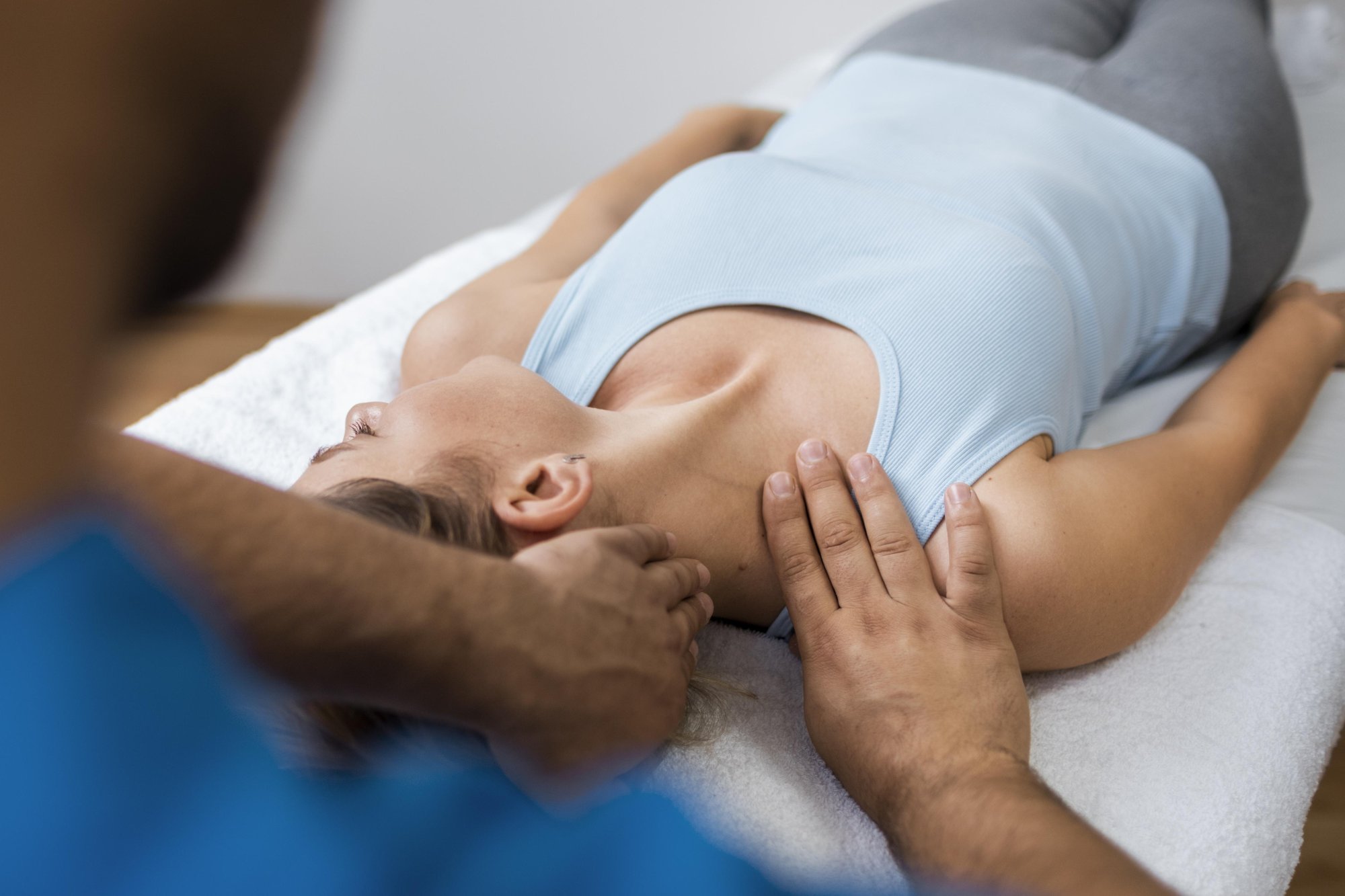 Osteopath behandelt sanft Nacken und Schultern einer Patientin